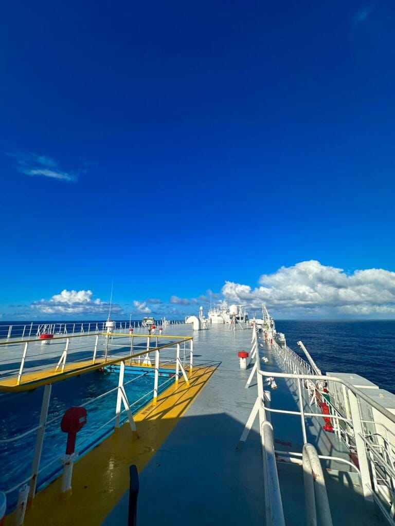 On the deck of a freight ship middle of pacific ocean.